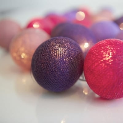 Nærbillede af en mørkeblå lyskugle fra IrisLights Vivid Violet lyskæden, med gyldne lysglimt inden i.