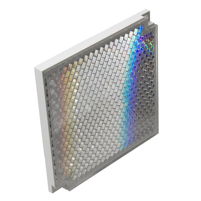 Carlo Gavazzi prismereflektor på 84,5 x 84,5 mm med sølvfarvet refleksgitter i grå ramme, set skråt forfra.