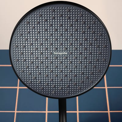 Hansgrohe Activera S 240 hovedbruser med grafit stråleskive og Hansgrohe logo, vist på en baggrund af mørkeblå fliser.