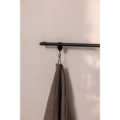 Metallbude Vana sort håndklædestang med et brunt håndklæde hængende på en diskret krog på en lys væg.