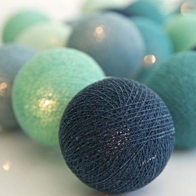 Detaljeret nærbillede af IrisLights Cool Mint lyskæde, viser mørkeblå stofkugler med LED-lys indeni.