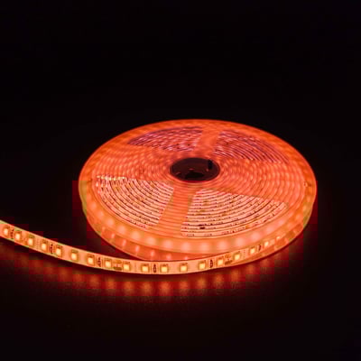 Orange LED strip på en rulle med 120 LED per meter, 10W per meter og 24V, sat i mørke omgivelser.