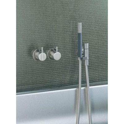 Vola indbygningsbrusesystem 2471 med et-grebsblander og håndbruser i krom, monteret på væg med tekstur.