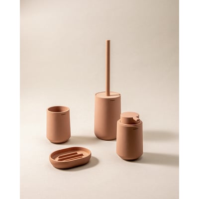 Cosmic fritstående sæbedispenser i mat rosa materiale, 85x140x85 mm, vist sammen med tilhørende badeværelsestilbehør.