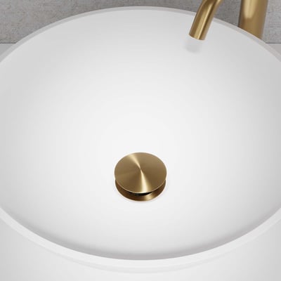 Lavabo Primy Steel Duo pop-up bundventil i børstet messing monteret i en hvid porcelænsvask med tilhørende messing vandhane.