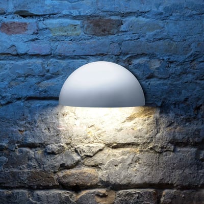 Lumenlight Bolero GII MIDI væglampe i hvid, monteret på en rustik murstensvæg med varmt lys nedad.