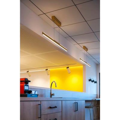 SLV ONE LINEAR 100 pendel i messing monteret i et moderne køkkenmiljø over en køkkenø.