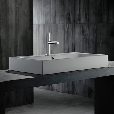 Hansgrohe AX Uno 110 håndvaskarmatur i krom monteret på en rektangulær håndvask, placeret på en mørk, betonlignende overflade.