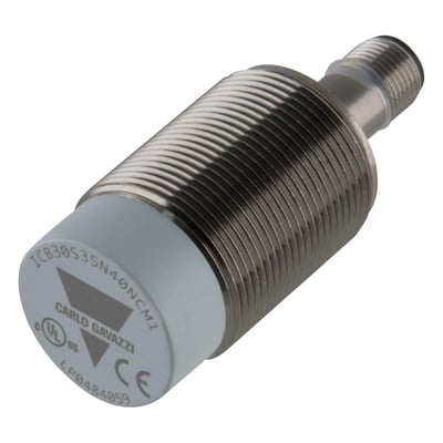Carlo Gavazzi induktiv aftaster M30 PNP NC med 40 mm detekteringsafstand, sølvfarvet gevindhus og grå front, set skråt.
