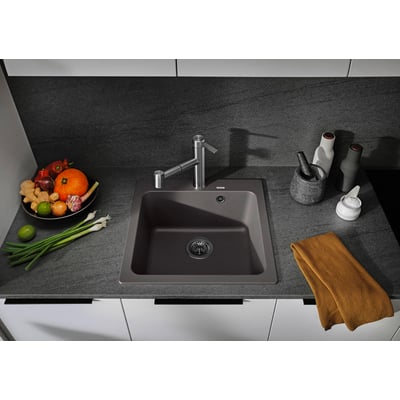 BLANCO NAYA 5 UX køkkenvask i sort Silgranit med armatur, placeret i et moderne køkken med grå bordplade og diverse grøntsager til højre.