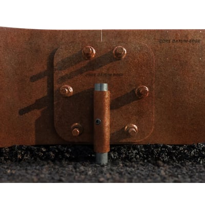 ECCO Products Core Datum kantskinnesæt i corten med synlig samling og bolte på en grusoverflade.