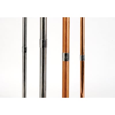 Forskellige rørtyper, herunder kobberrør og stålrør, med monterede Instalpress klemmeforbindere, vist på hvid baggrund.