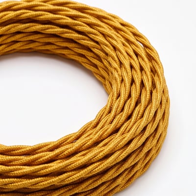 Guldfarvet, twistet stofledning med tekstilflet ligger oprullet; ledningen er 5 meter lang og beregnet til 230 V.