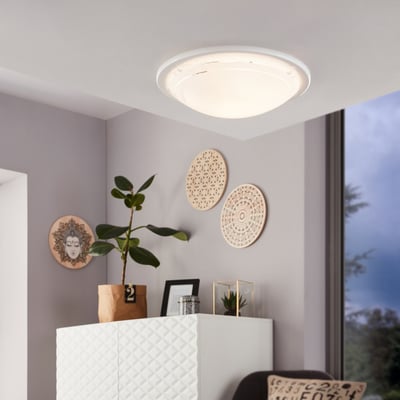 EGLO Planet 1 loftlampe i hvid, rund med en diameter på 29 cm. Lampen er monteret i et moderne rum med planter og dekorationer på væggen.