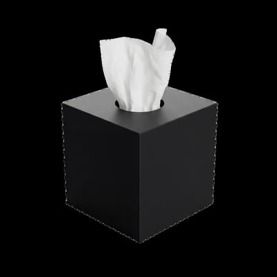 Sort Nichba Kube servietdispenser med hvid serviet trukket op gennem åbningen, set skråt forfra.