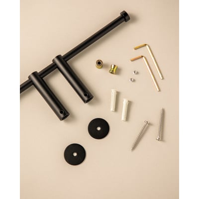 Cosmic Logic toiletpapirholder i mat sort, vist med tilbehør til montering som skruer og rawlplugs.