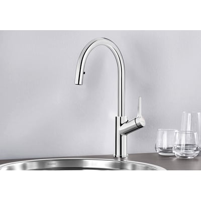 BLANCO carena-s køkkenarmatur i blank krom med udtræksbruser og svingbar C-tud, monteret ved en køkkenvask.