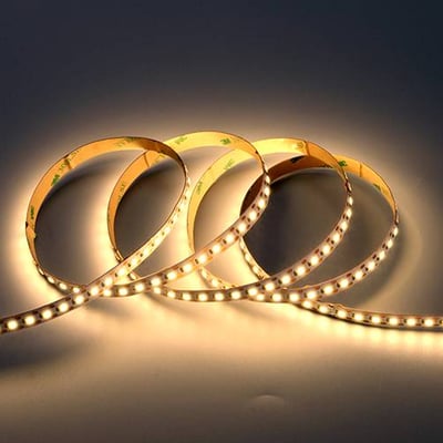 Fleksibelt Ansell Lighting K-Cell LED bånd på 5 meter, 2700K varmt lys, viklet op i blød belysning.