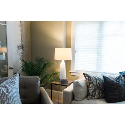 Ledvance LED Value Standard pære med E27 sokkel i et hyggeligt stuemiljø med en sofagruppe og en grøn plante.