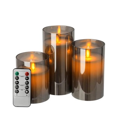 Tre LEDlife bloklys i røgfarvet glas, Ø7,5 cm, med fjernbetjening vist ved siden af på en hvid baggrund.