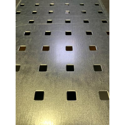 Maskinfabrikken Universal hulplade 1000x2000mm i varmgalvaniseret stål med firkantede huller. Billedet viser tæt på og i vinkel mønsteret af hullerne.