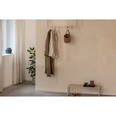 Metallbude Rubi lofthængt tøjstativ i beige metal, 60x80 cm, vist med tøj hængende på væggen ved siden af en plante og en kurv.