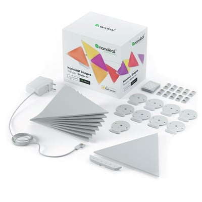 Nanoleaf Shapes Triangles sat op på en mørkegrøn væg i et spiseområde med et unikt og farverigt lysmønster.