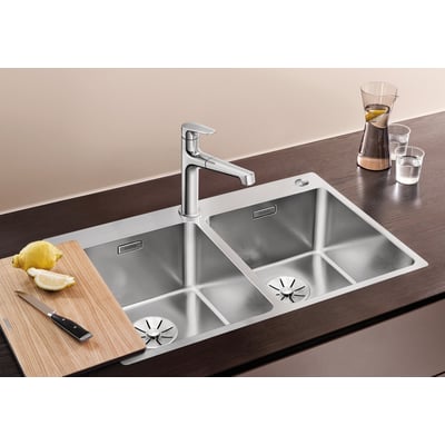 BLANCO ANDANO 340/340-IF/A MXI køkkenvask med tilbehør som skærebræt, kniv og citron, viser vaskens funktionelle design.