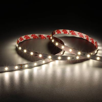 Nærbillede af et Ansell Lighting E-Cell Eco LED bånd med 3M tape på bagsiden, vist på mørk baggrund.