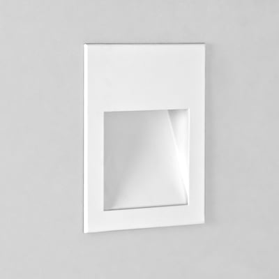 Astro Borgo 90 LED væglampe i mat hvid monteret på en grålig væg, med et rektangulært lysindtag.