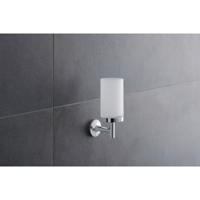 Duravit Starck T glasholder i krom med matteret glas monteret på en grå flisevæg, set skråt forfra.