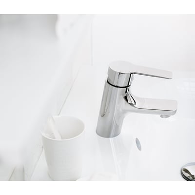 Mora Cera B5 håndvaskarmatur i krom monteret på en hvid porcelænsvask, ved siden af en hvid holder med tandbørster.