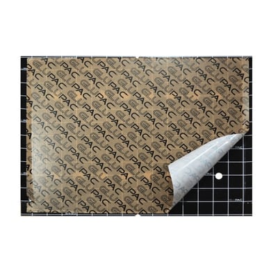 Infiniti limplade med et gentagende GLUPAC mønster på en brun baggrund, vist på et gitterunderlag med en afrivningsflig.