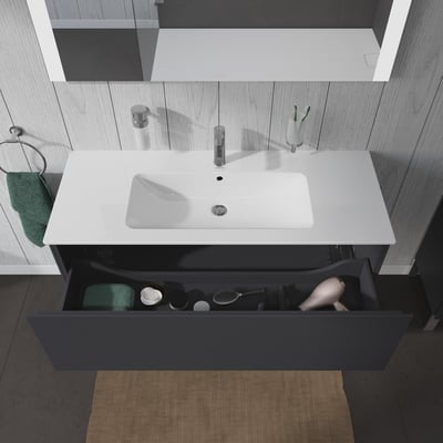Duravit L-Cube underskab i mørkegrå med et stort udtræk, der indeholder et håndklæde, en hårtørrer og toiletartikler.