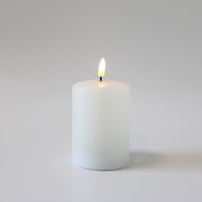 Et enkelt LEDlife bloklys i hvid med en lys flammeeffekt på en ren hvid baggrund, der fremhæver lysets form og design.