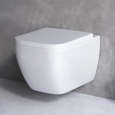 AM.PM Gem væghængt toilet i hvid, kompakt design med sæde-cover, monteret på betonvæg.