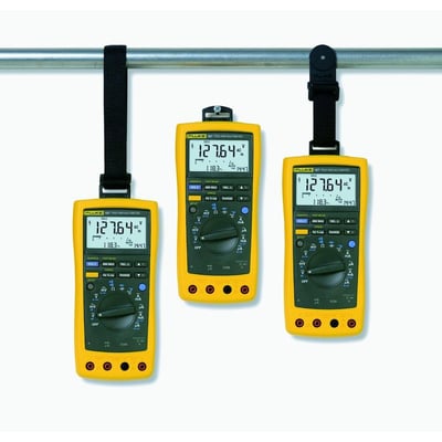 Tre gule Fluke multimetre hængt op på en stang ved hjælp af Toolpak meterophængssætets stropper og magnet.