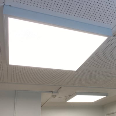 To oplyste 60x60 cm LED paneler monteret i et hvidt akustikloft ved hjælp af Green-ID Click rammer.