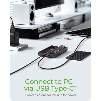 Sort ICY BOX-kabinet til to M.2 PCIe NVMe-SSD'er er tilsluttet med kabler på et skrivebord.