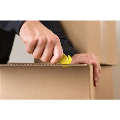 Hånd bruger en gul Klever KCJ-1 sikkerhedsskærer til at åbne en papkasse, hvilket viser dens anvendelse.