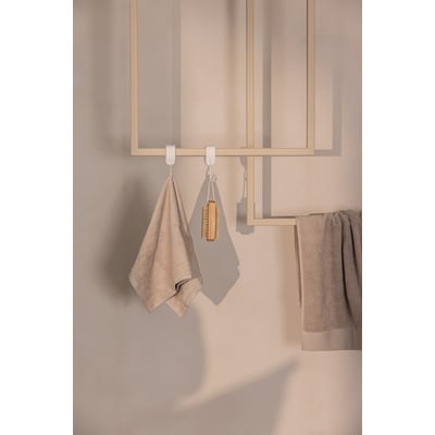 Metallbude Tensi håndklædeholder i beige med to håndklæder og en vaskebørste hængende på hvid krog.