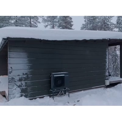 Panasonic CU-2Z50ABEC udedel monteret udenfor et hus om vinteren, dækket af sne og frost.