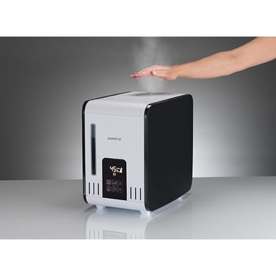 En hånd fører over dampen fra Boneco S450 luftfugteren, der viser dens varmdampfunktion.