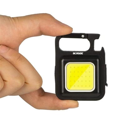 Ironside Micro genopladelig håndlampe med sort hus, gul lysflade og karabinhage holdes mellem fingrene.