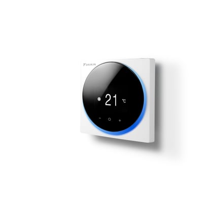 Daikin rumtermostat i hvidt, set skråt forfra med rundt sort display, blå lyskant og visning af 21 °C.