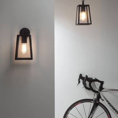 Astro 7105 Calvi vægarmatur installeret på hvid væg ved siden af en cykel, viser lampens alsidighed og stil.