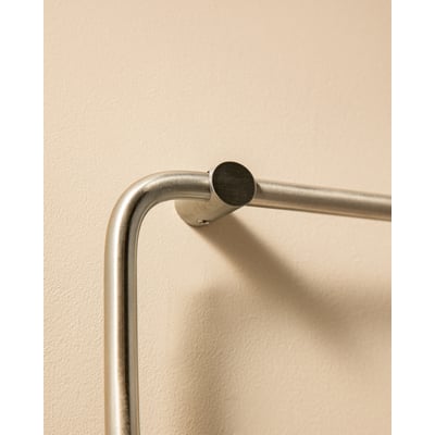 Cosmic Logic håndklædeholder, 20 cm, i poleret rustfrit stål, monteret på en lys væg.