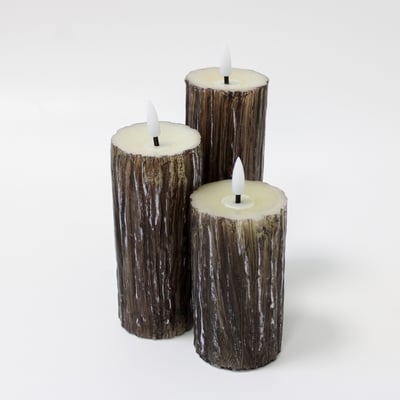 Tre LEDlife bloklys i træ-look med smelteeffekt, der viser deres forskellige højder på en hvid baggrund.