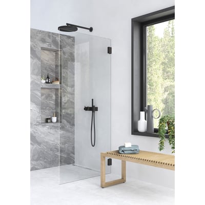 Contura Showerama Art brusevæg 120x200 cm med klart 8 mm glas og sorte matte beslag, vist i moderne badeværelse med grå marmorvæg.