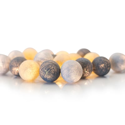 Detaljeret billede af Irislights lyskædens tekstilkugler i nuancer af grå og creme, tæt arrangeret med varm belysning.